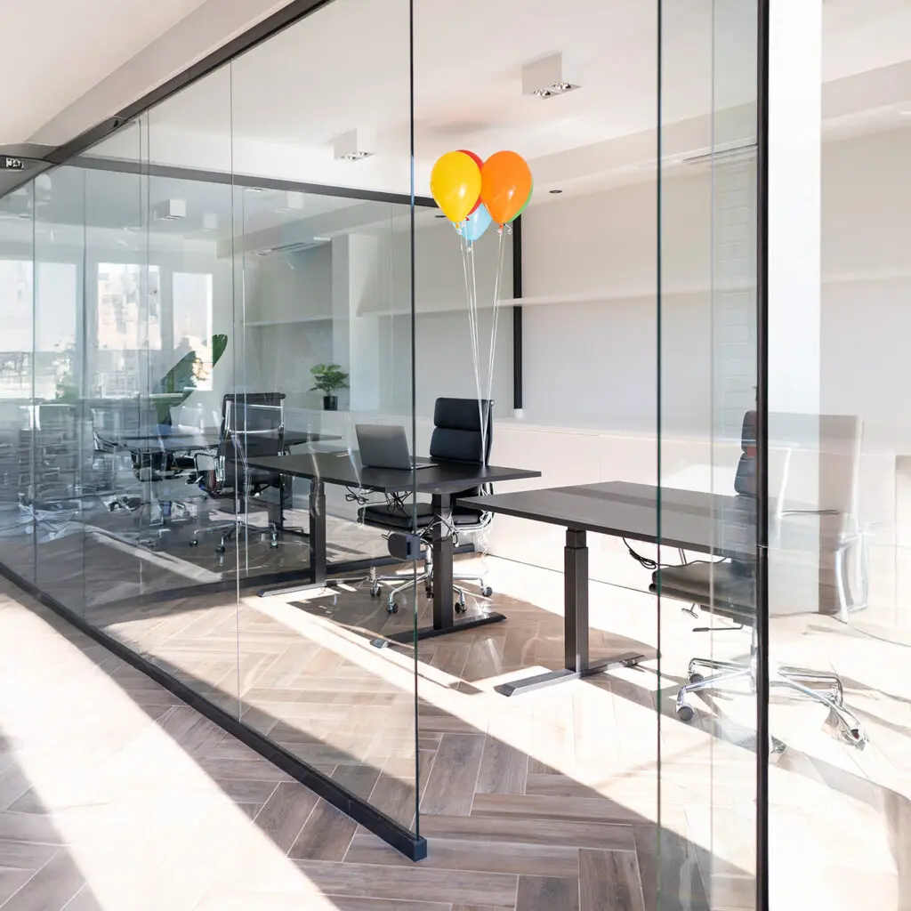 Frameless glass partitions creating modern office zones with natural light