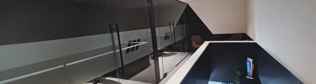 Glass partitions in a commercial office space with matt black fittings