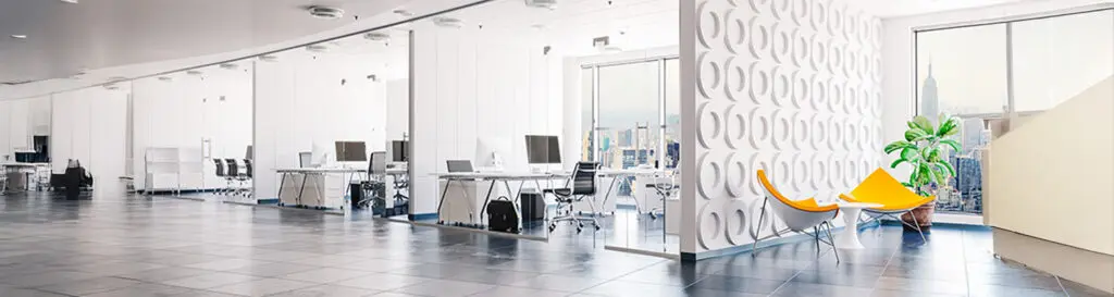 Modern open-plan office showing both glass partition walls and traditional drywall meeting rooms