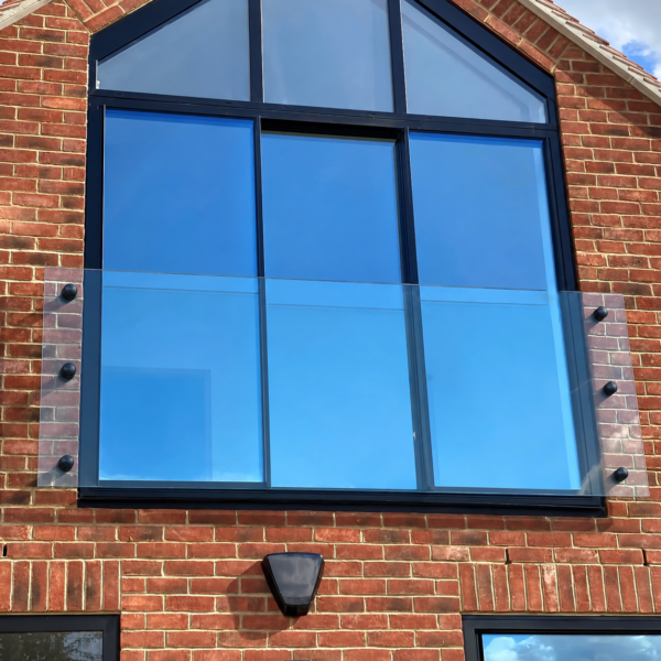 Black frameless glass Juliet balcony with black circular fittings